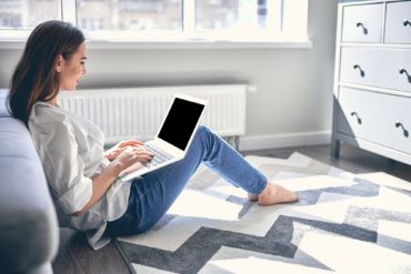 Pretty young lady using her laptop for job