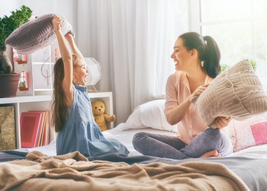 mother and her child are fighting pillows