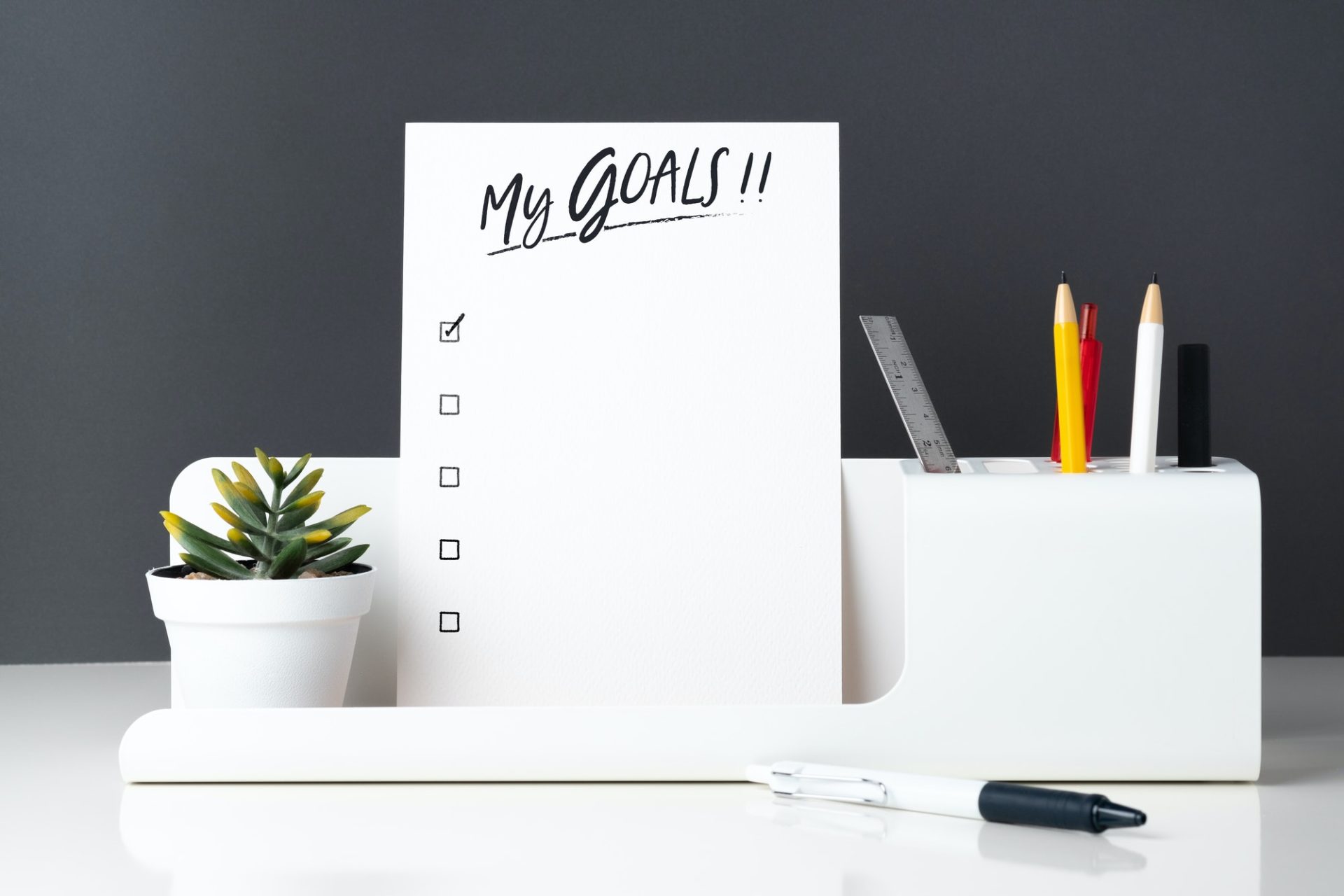 My goals list on notepad at modern office stationery on white table