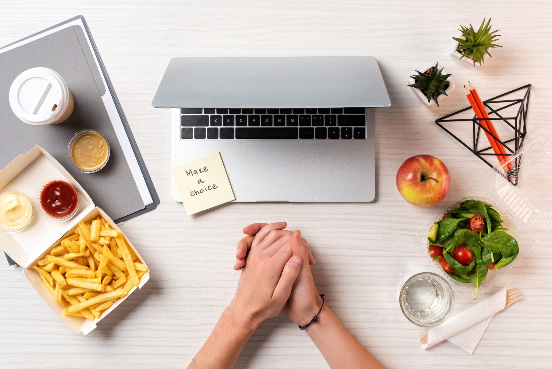 partial top view of female hands, laptop, note with inscription make a choice and healthy food with