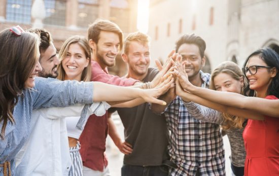 Young happy people stacking hands outdoor